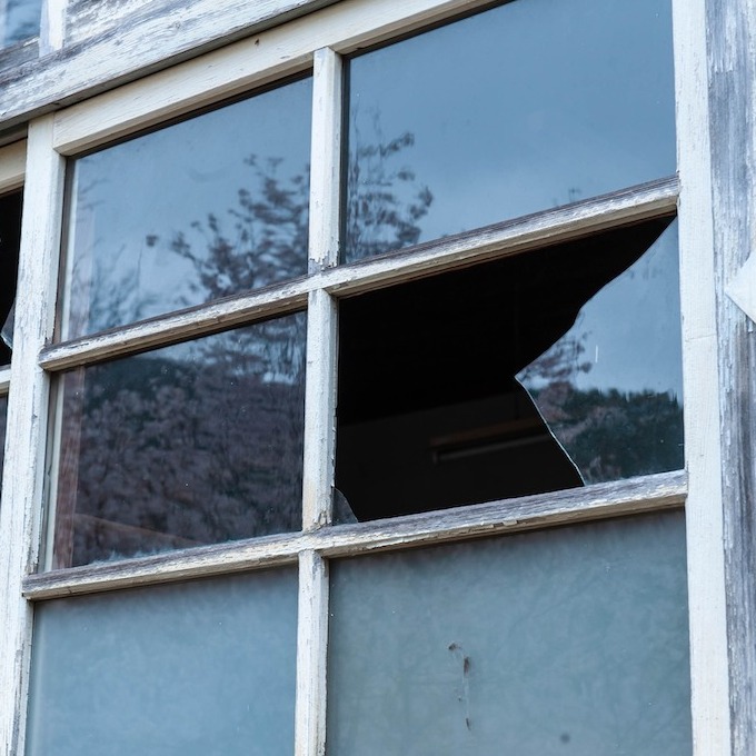A dusty broken window in a set of six window panes