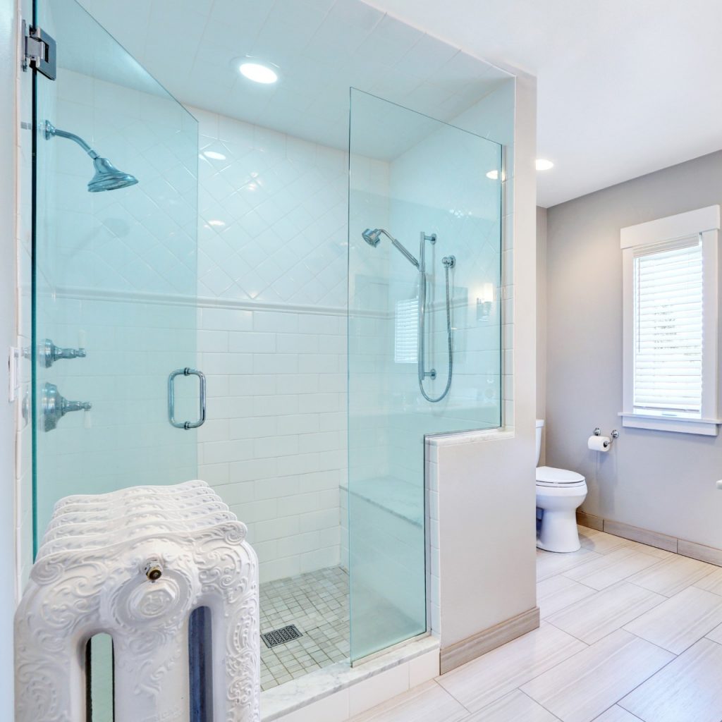 large sitting shower with two shower heads and a frameless glass exterior